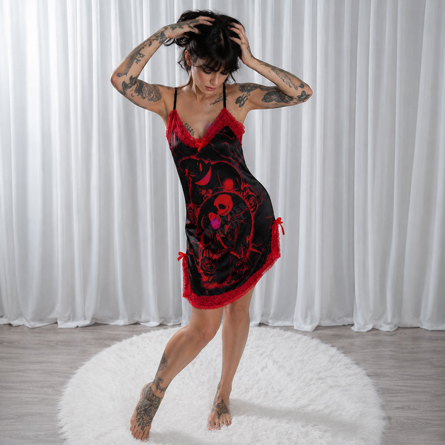 Experience better sleep with the Wonder Skull Chemise Nightgown. Its buttery-soft satin feels amazing, while red lace panels at the neckline, sides, and hem keep you cool all night. The adjustable straps and flowing A-line silhouette allow for a comfortable, non-restrictive fit. Bold red crackle skeleton artwork is balanced by sweet satin bows, adding a feminine touch.
