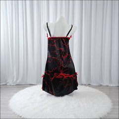 Experience better sleep with the Wonder Skull Chemise Nightgown. Its buttery-soft satin feels amazing, while red lace panels at the neckline, sides, and hem keep you cool all night. The adjustable straps and flowing A-line silhouette allow for a comfortable, non-restrictive fit. Bold red crackle skeleton artwork is balanced by sweet satin bows, adding a feminine touch.