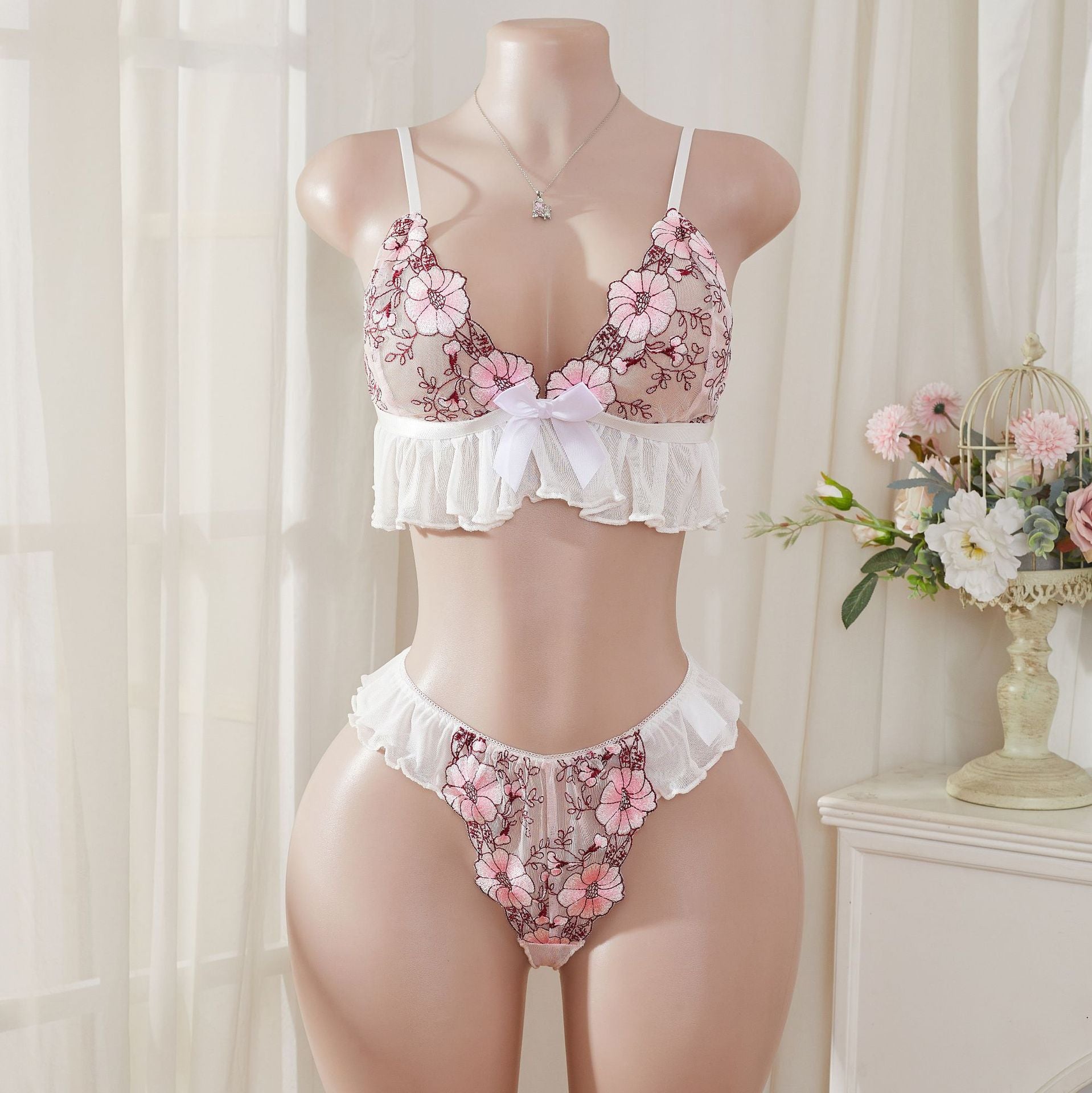 Wonder Skull Pink Floral Lace Embroidered Ruffle Bralette and Panty Set offers a feminine look without uncomfortable squeezing or digging. Its wire-free, soft cup design and breathable mesh fabric allow for natural movement while keeping you cool. The smooth floral embroidery adds a touch of romance without causing irritation. Adjustable straps and a hook-and-eye closure ensure a custom, secure fit. Finished with sweet white ruffle trim and satin bows, this set is designed to make you feel both beautiful an