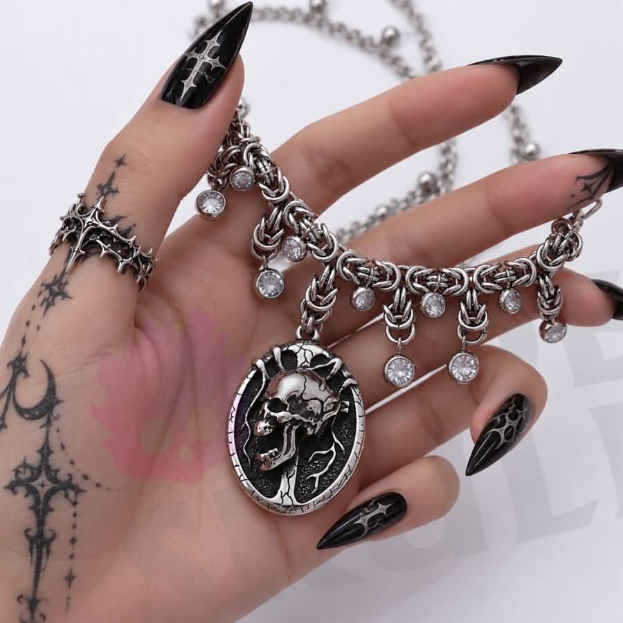 A gothic day collar featuring a silver-tone chain, cracked black-and-silver skull centerpiece, and clear faceted accents. Available in two lengths with a 1.97-inch extension and secured with a lobster clasp.