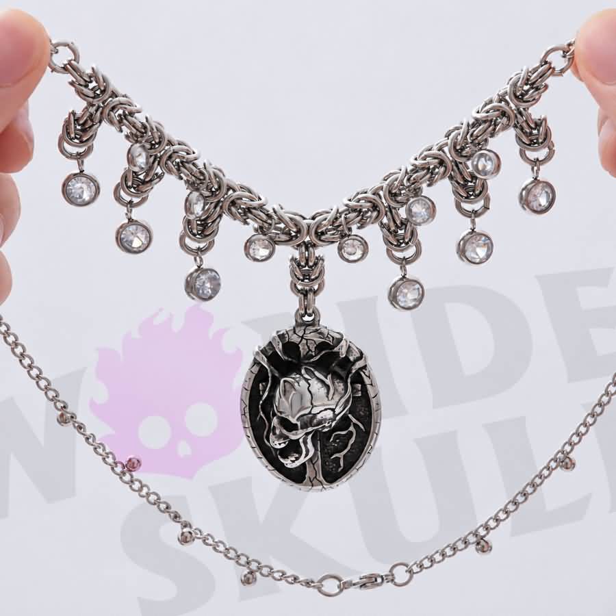 A gothic day collar featuring a silver-tone chain, cracked black-and-silver skull centerpiece, and clear faceted accents. Available in two lengths with a 1.97-inch extension and secured with a lobster clasp.