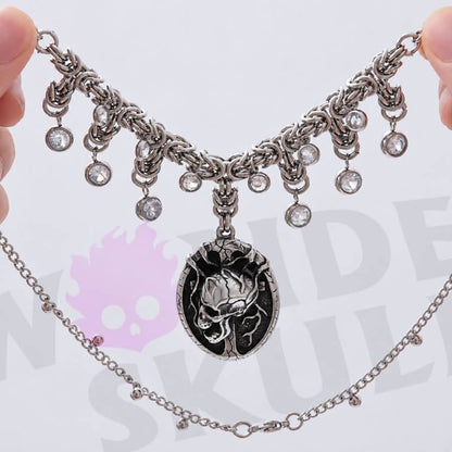 A gothic day collar featuring a silver-tone chain, cracked black-and-silver skull centerpiece, and clear faceted accents. Available in two lengths with a 1.97-inch extension and secured with a lobster clasp.