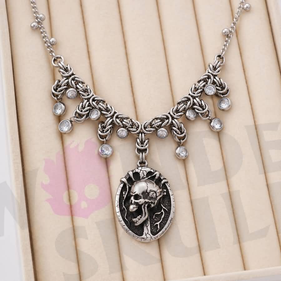 A gothic day collar featuring a silver-tone chain, cracked black-and-silver skull centerpiece, and clear faceted accents. Available in two lengths with a 1.97-inch extension and secured with a lobster clasp.