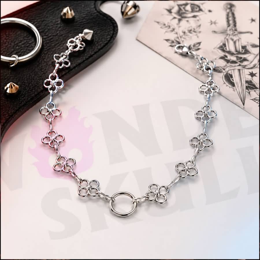 Wonder Skull Flower Link O-Ring Day Collar A quiet promise of devotion. This day collar features delicate stainless steel blossoms meeting at a polished 1.6 cm O-ring. Waterproof, tarnish-resistant, and built for 24/7 wear, it is available in 16" or 18" lengths. It is subtle enough to pass as everyday jewelry, yet unmistakable to those in the know. Pretty on the surface, unbreakable underneath.