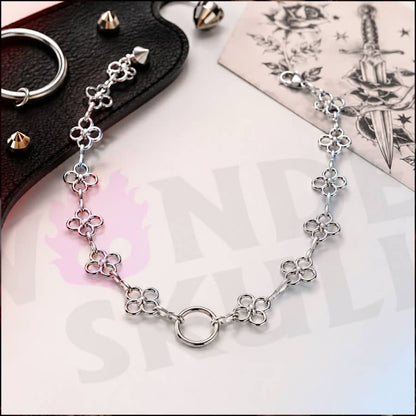 Wonder Skull Flower Link O-Ring Day Collar A quiet promise of devotion. This day collar features delicate stainless steel blossoms meeting at a polished 1.6 cm O-ring. Waterproof, tarnish-resistant, and built for 24/7 wear, it is available in 16" or 18" lengths. It is subtle enough to pass as everyday jewelry, yet unmistakable to those in the know. Pretty on the surface, unbreakable underneath.