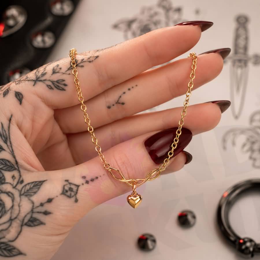 Wonder Skull Gold Heart Charm Day Collar Stainless Steel Sub Necklace. A quiet promise for everyday wear. A dainty gold-tone chain connects a Celtic-style twist to a puffed heart charm—a discreet symbol only the two of you understand. Built for 24/7 wear, it's waterproof, tarnish-free, and hypoallergenic. Available in 16" or 18", it looks like everyday jewelry but means too much to ever take off. Devotion you wear. Strength you keep.