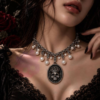 Wonder Skull Queen Pearl Chain Statement Necklace features a crowned skull pendant with silver-tone chainwork and faux-pearl accents. Its layered collar design blends dark romance with vintage glamour, making it perfect for gothic, alternative, or special occasion looks.