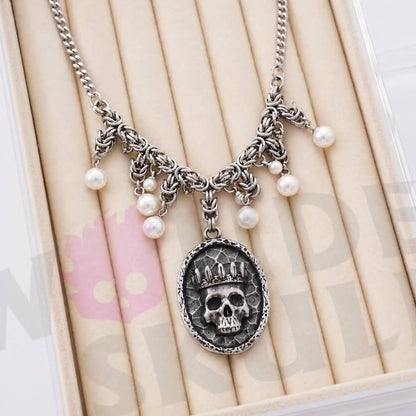 Wonder Skull Queen Pearl Chain Statement Necklace features a crowned skull pendant with silver-tone chainwork and faux-pearl accents. Its layered collar design blends dark romance with vintage glamour, making it perfect for gothic, alternative, or special occasion looks.
