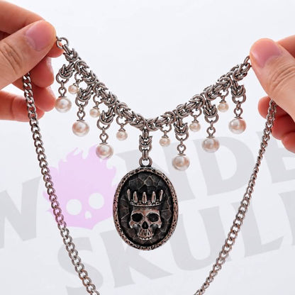 Wonder Skull Queen Pearl Chain Statement Necklace features a crowned skull pendant with silver-tone chainwork and faux-pearl accents. Its layered collar design blends dark romance with vintage glamour, making it perfect for gothic, alternative, or special occasion looks.