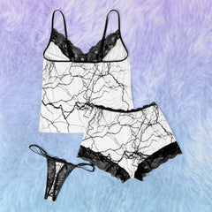 Wonder Skull White Lightning 3-Piece Gothic Sleepwear Set blends edgy design with elegant details. This set includes a white cami adorned with a bold lightning print, Gothic-inspired pajama shorts with stylish lettering, and delicate black lace accents. A coordinating thong completes the look, making it an ideal choice for those who appreciate loungewear that’s equal parts artistic, fashionable, and comfortable.