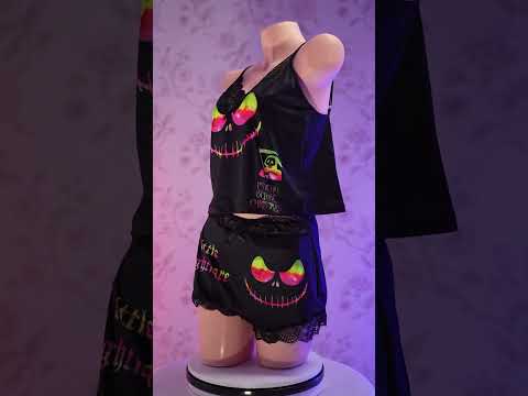 Transform your nighttime routine with the Wonder Skull glow-in-the-dark sleepwear set. The vibrant rainbow skull graphics absorb light by day and glow when darkness falls. Made from a buttery-soft, breathable fabric, this set keeps you cool all night. The delicate, dotted lace trim adds a feminine touch without being scratchy, while adjustable spaghetti straps ensure a perfect fit. This three-piece set includes a matching cami, shorts, and thong, letting you express your bold personality in comfort.